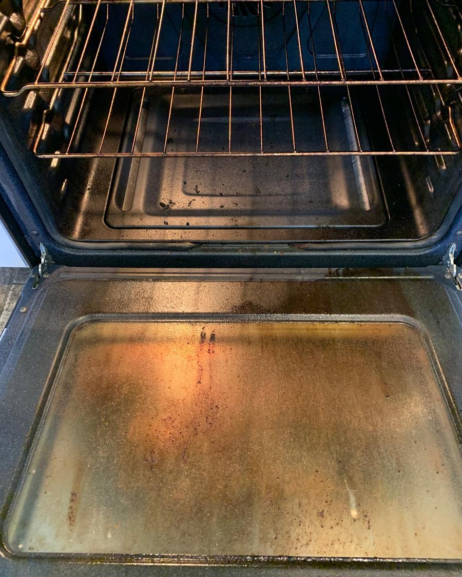 A greasy oven interior before RosyGloves cleaned it
