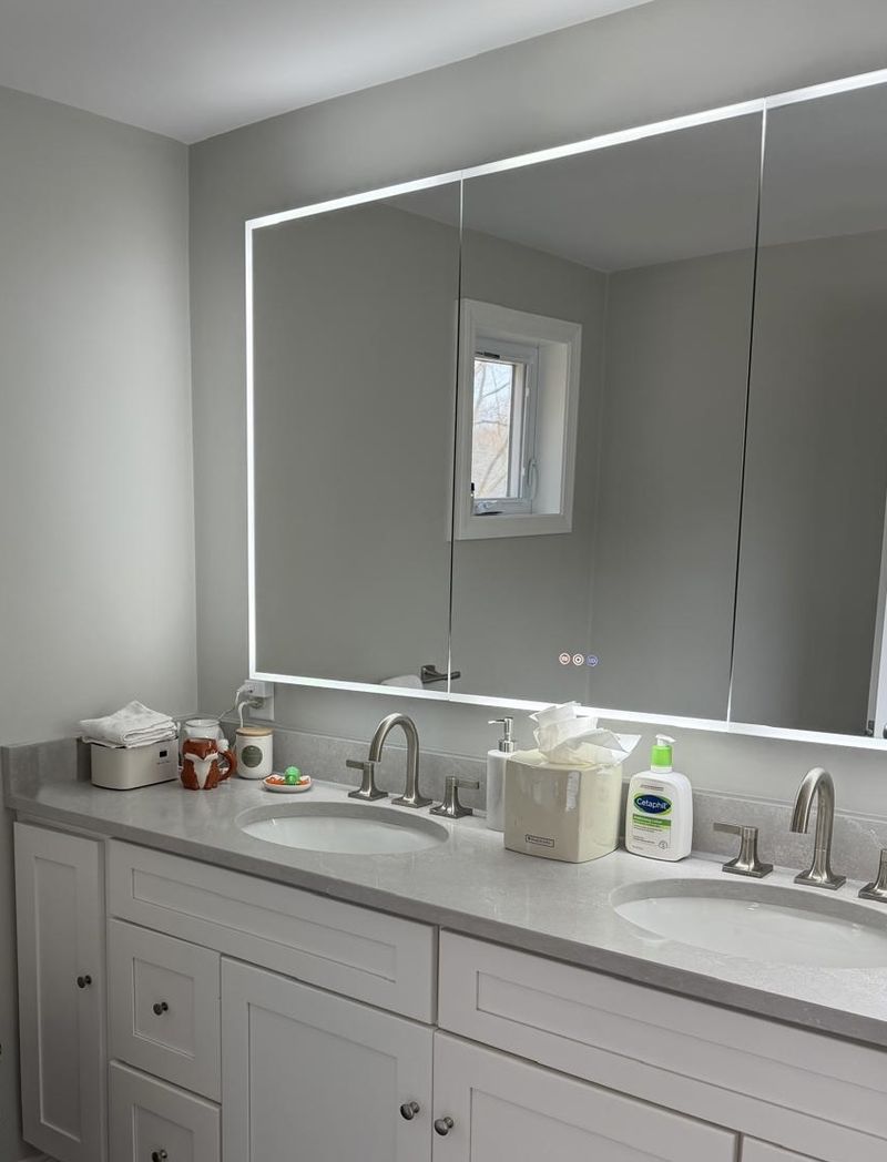 A double vanity with a lit mirror cleaned streak-free