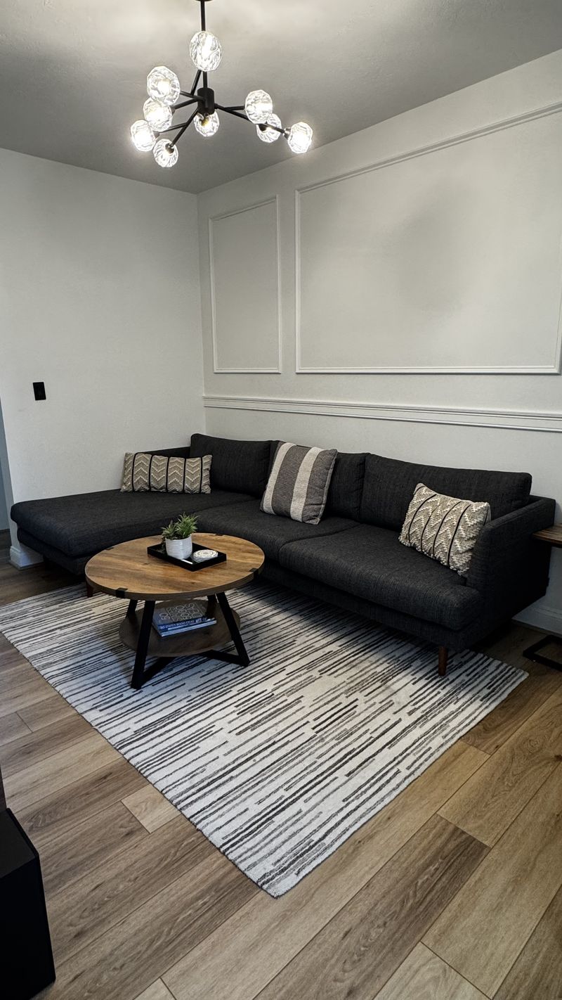 A living room reset, rug straightened and surfaces dusted
